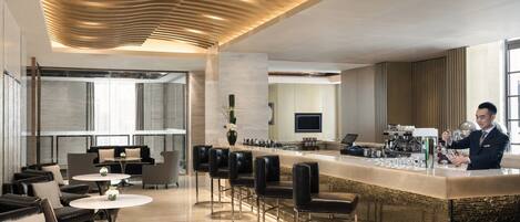 Eine moderne Bar mit Bartender, Ledersitzgelegenheiten und einem glatten Boden.