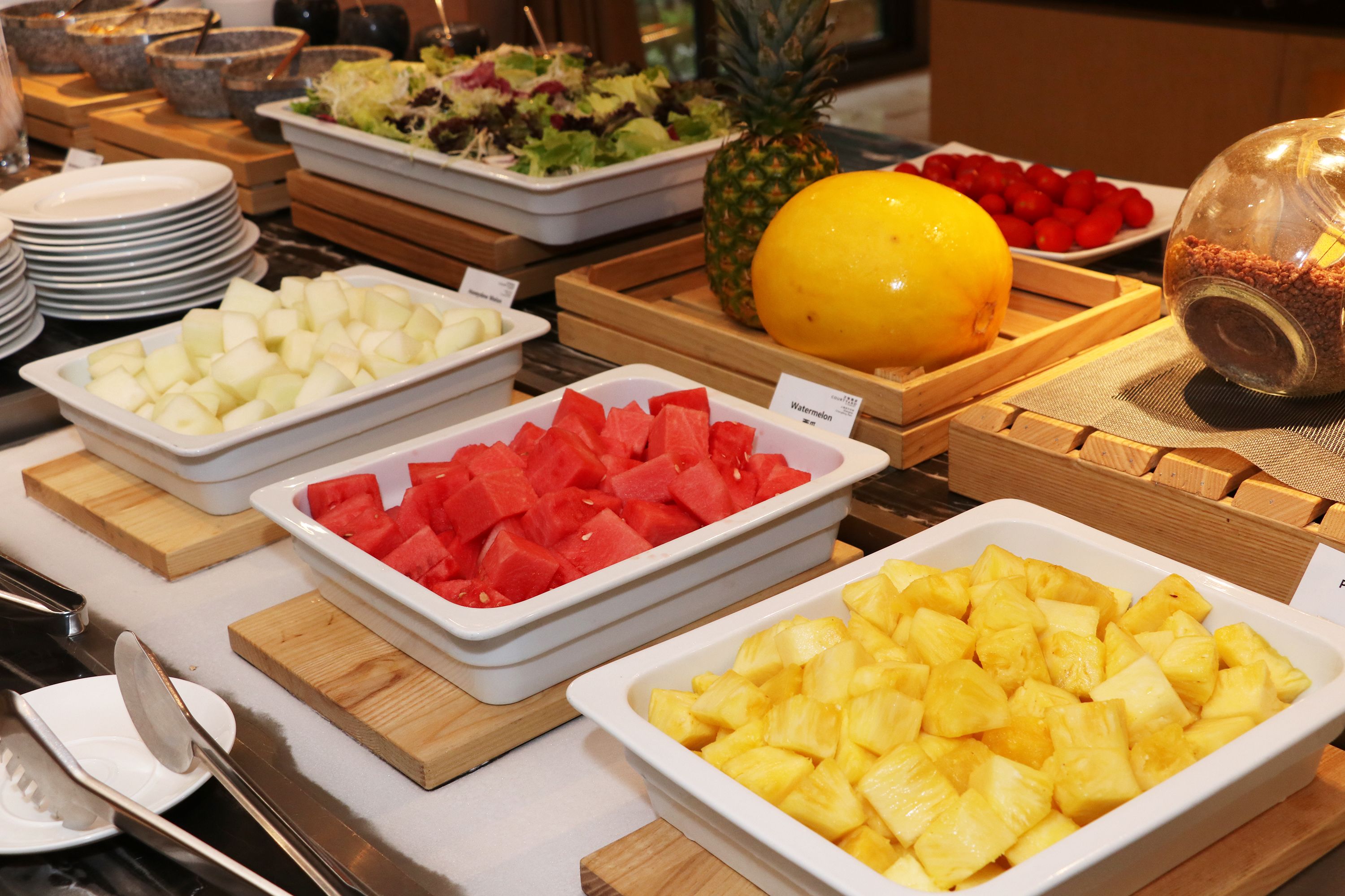 Un buffet proposant une variété de fruits et de salades.