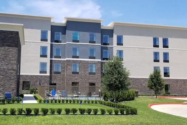 Una piscina al aire libre, sillones reclinables de piscina