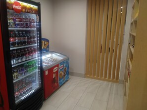 A vending machine with various drinks and a Nestle ice cream freezer. - Holiday Inn Express & Suites Sugar Land SE - Missouri City by IHG (Missouri City)