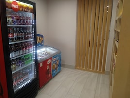 A vending machine with various drinks and a Nestle ice cream freezer.