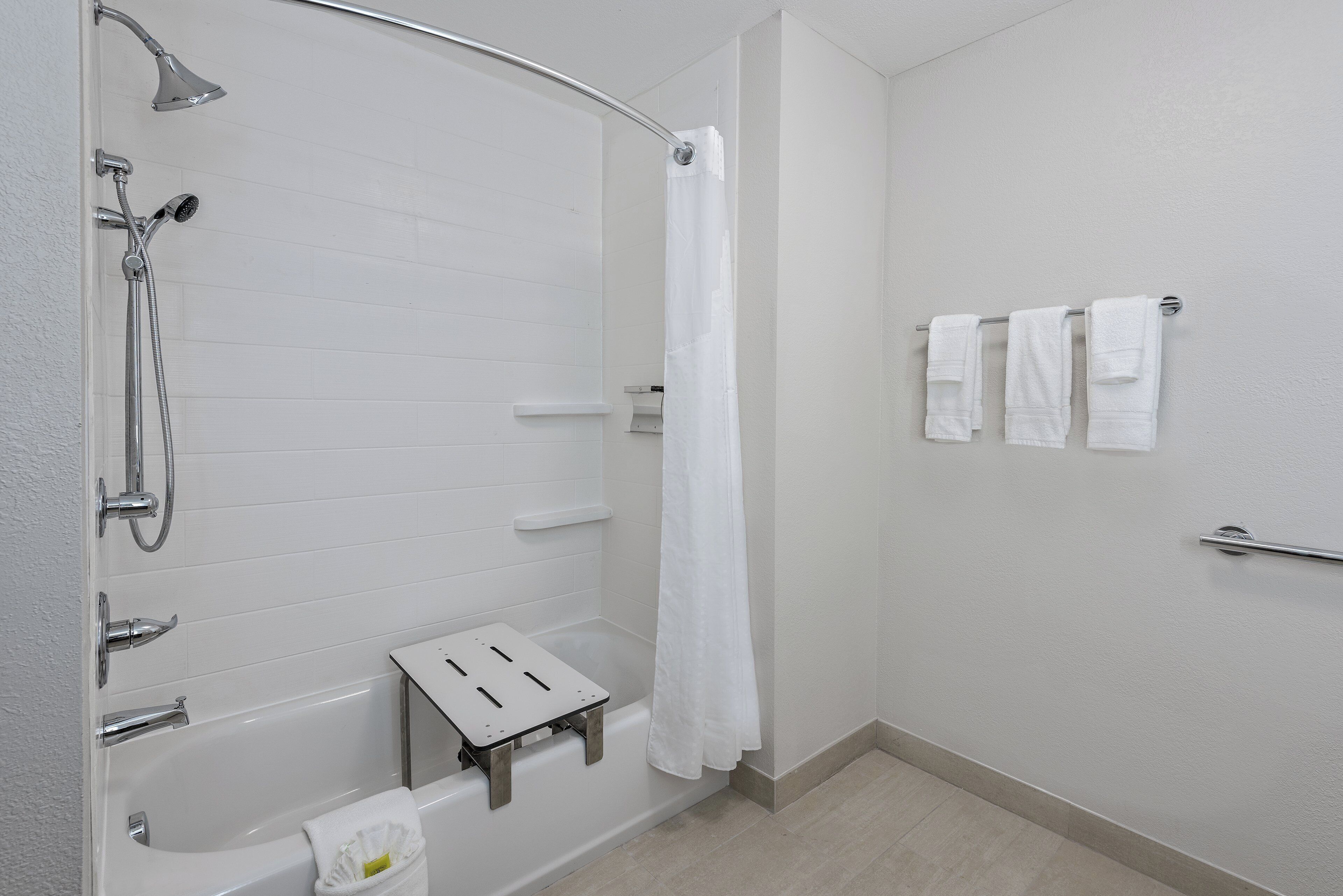 Un baño con bañera, ducha y toallero.