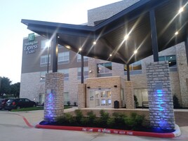A Holiday Inn Express & Suites building with a stone facade, a covered entrance, and a fire lane.
