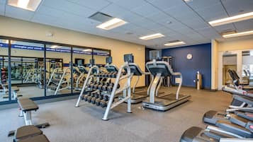 A gym with treadmills, dumbbells, and exercise equipment.