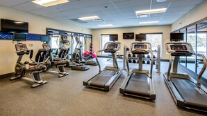 A gym with treadmills, elliptical machines, and weight equipment.
