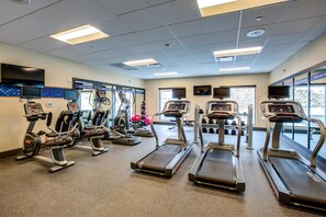A gym with treadmills, elliptical machines, and weight equipment. - Hampton Inn & Suites Boston/Waltham (Waltham)