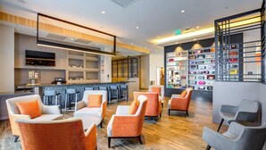 Un espace lounge moderne comprenant des sièges, un bar et une exposition d’objets décoratifs.