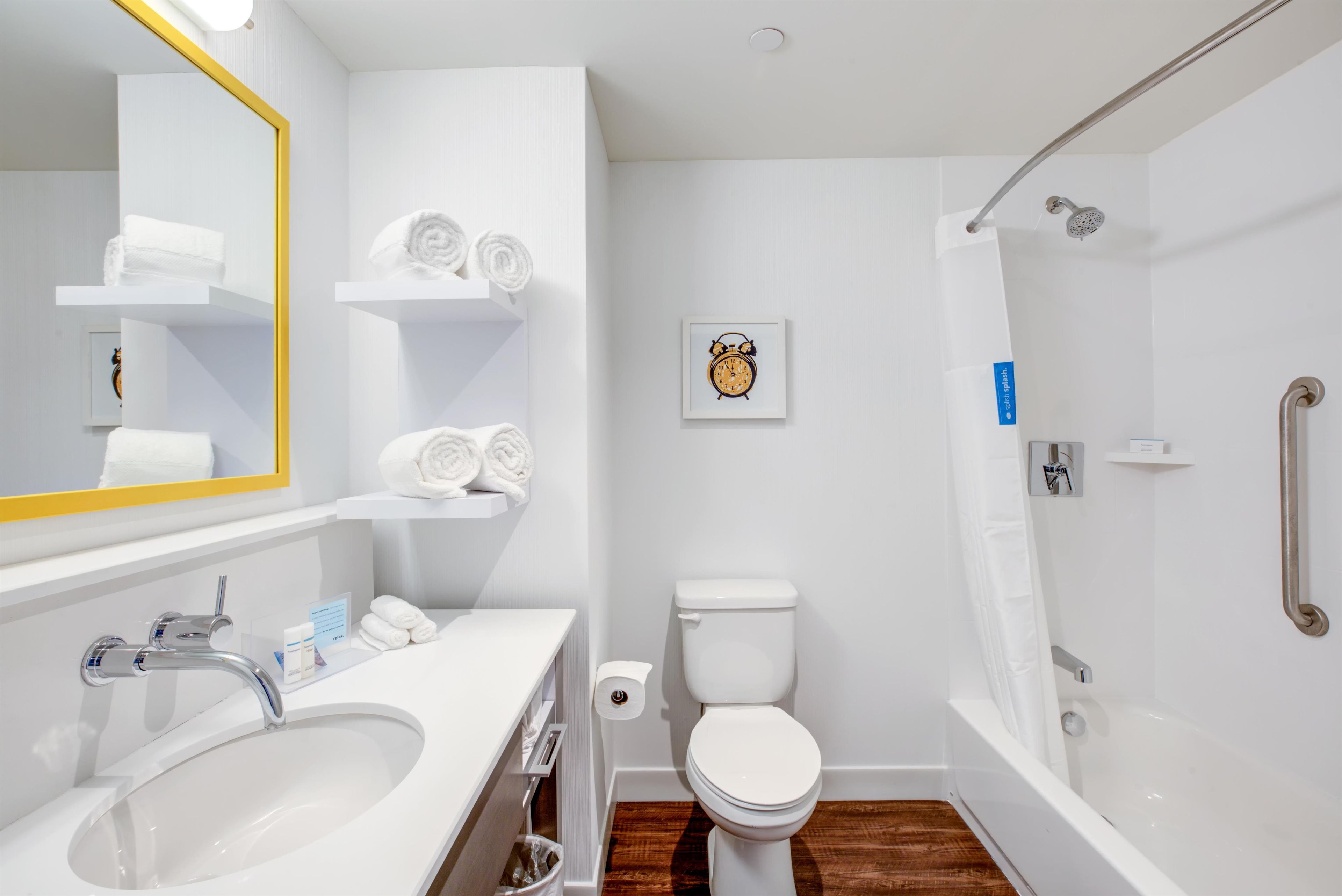 Une salle de bain moderne équipée d’un lavabo, de toilettes et d’une douche.