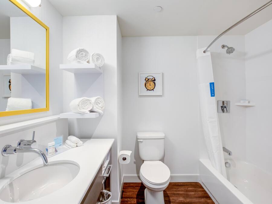 Une salle de bain moderne équipée d’un lavabo, de toilettes et d’une douche.