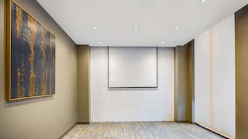 A modern hotel room with a large abstract painting, a patterned wall, and a recessed ceiling with lights.