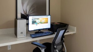 A computer desk with a monitor, keyboard, and chair. - Candlewood Suites Goodlettsville - Nashville by IHG (Goodlettsville)