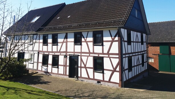 A traditional half-timbered house with a steeply pitched roof, multiple windows, and a chimney. - Gräfrath Gästehaus Neunkirchen-Seelscheid (Neunkirchen-Seelscheid)