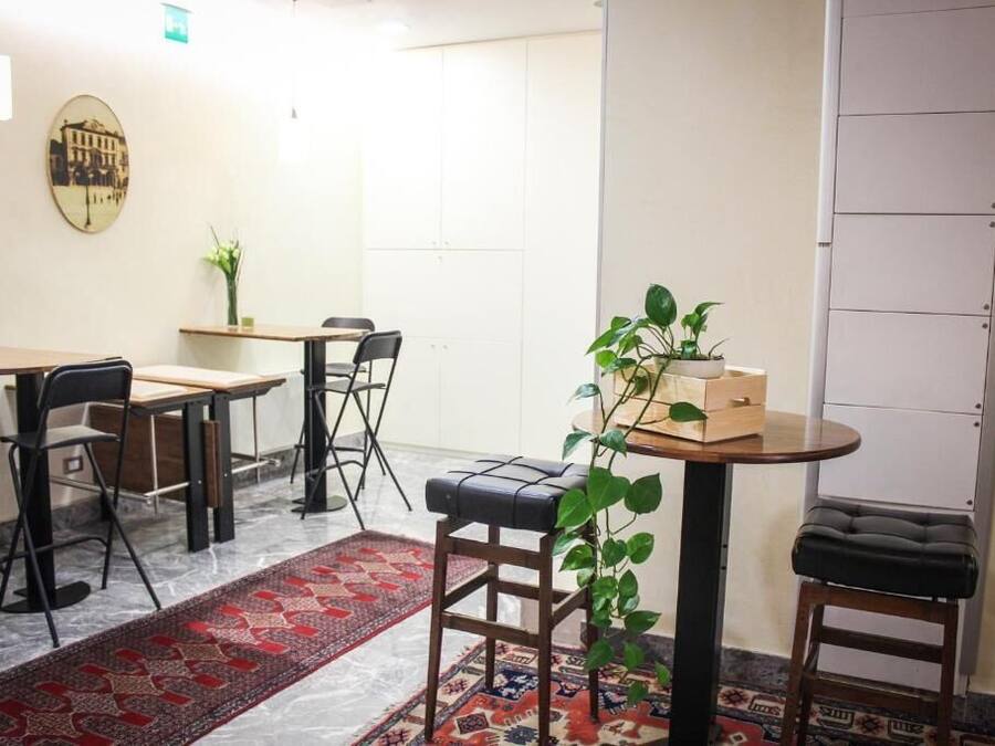 Une pièce comprenant une table à manger, des chaises, une petite table ronde avec une plante et un banc.