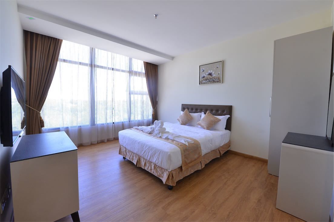 Habitación de hotel con una cama grande, una televisión de pantalla plana y un escritorio.