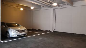 A parking garage with a white car parked in a designated space.