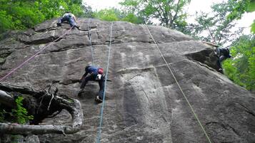 A large rock climbing route with multiple climbers ascending.