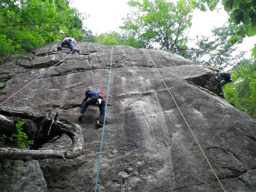 A large rock climbing route with multiple climbers ascending.