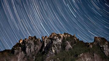 A mountain range with star trails in the night sky.