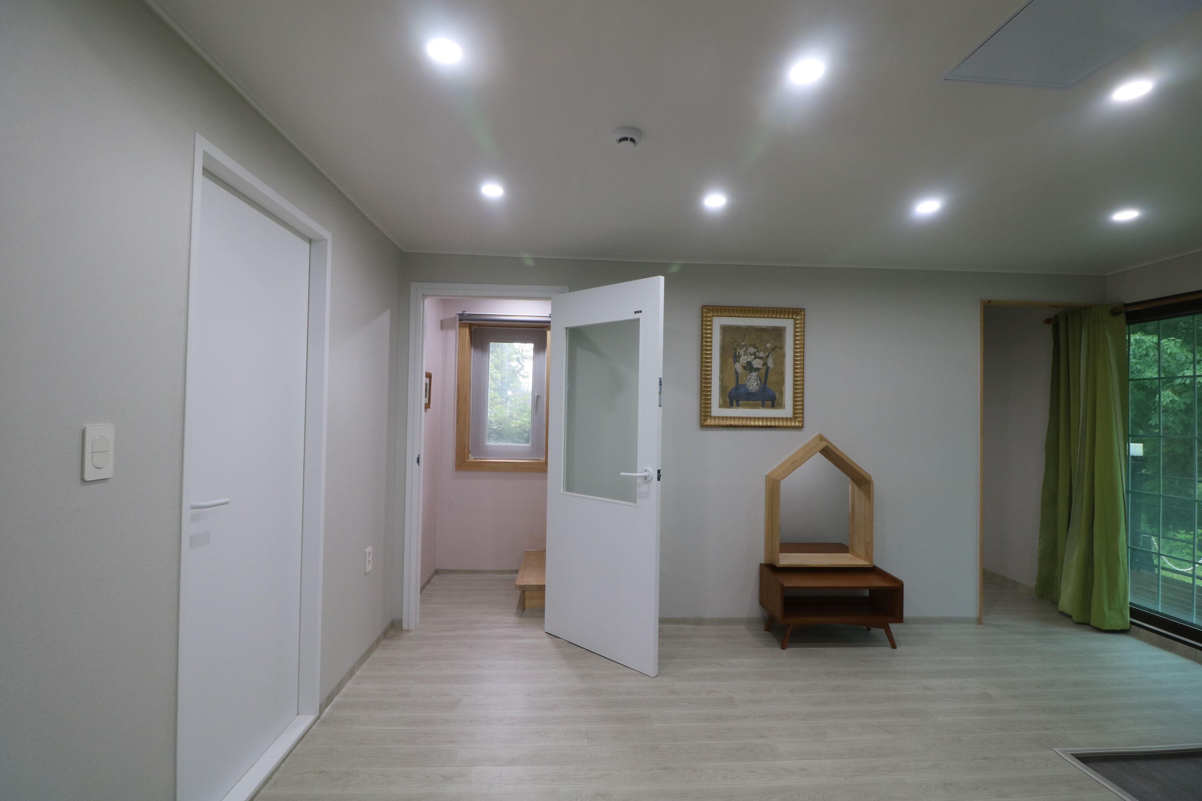 A modern room with a wooden bench, a door, and a window with a view.