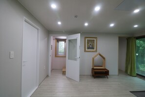 A modern room with a wooden bench, a door, and a window with a view. - Bandibyeol Pension (Hongcheon)