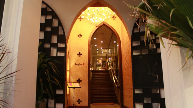 An arched entrance with a reception desk, a staircase, and a chandelier. - Jam Hostel Bangkok (Bangkok)