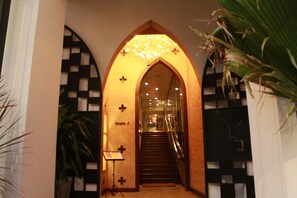 An arched entrance with a reception desk, a staircase, and a chandelier. - Jam Hostel Bangkok (Bangkok)