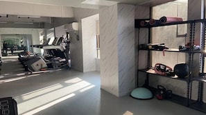 A gym with treadmills, a weight bench, and a rack of weights.