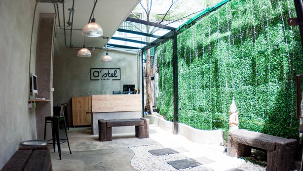 A cozy outdoor seating area with wooden benches and a stone pathway. - A'stel Bangrak - Adults Only - Hostel (Bangkok)