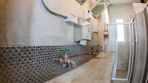 A narrow bathroom with a tiled backsplash, a toilet, and a shower area. - A'stel Bangrak - Adults Only - Hostel (Bangkok)