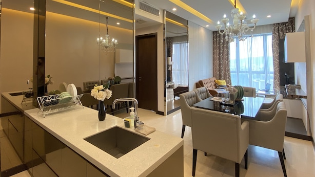A modern living room with a dining area, a large mirror, and a chandelier. - Dorsett Residences Bukit Bintang by De Space (Kuala Lumpur)