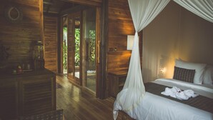 A wooden room with a bed, a nightstand, a lamp, and a window with curtains. - Desa Saya Eco Luxury Resort & Spa (Tejakula)