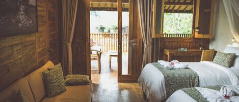 A wooden room with two beds, a sofa, and a balcony with a wooden railing.