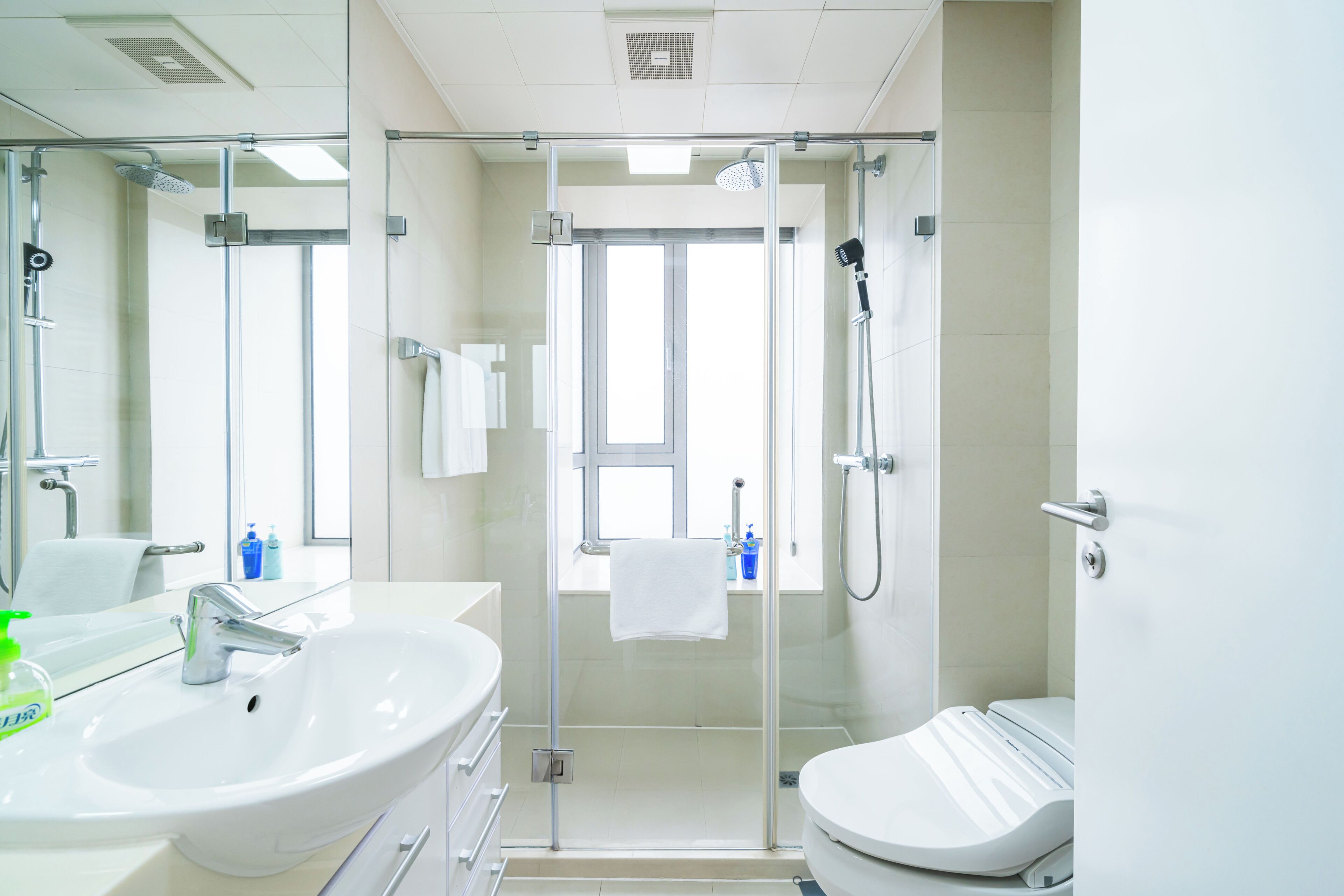 Un bagno moderno con cabina doccia in vetro, lavabo bianco e water.