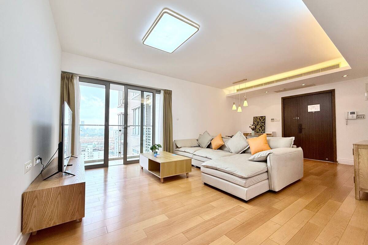 A modern living room with a sofa, coffee table, and a TV.