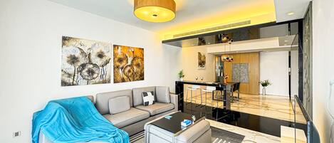 A modern living room with a sofa, coffee table, and artwork on the wall.
