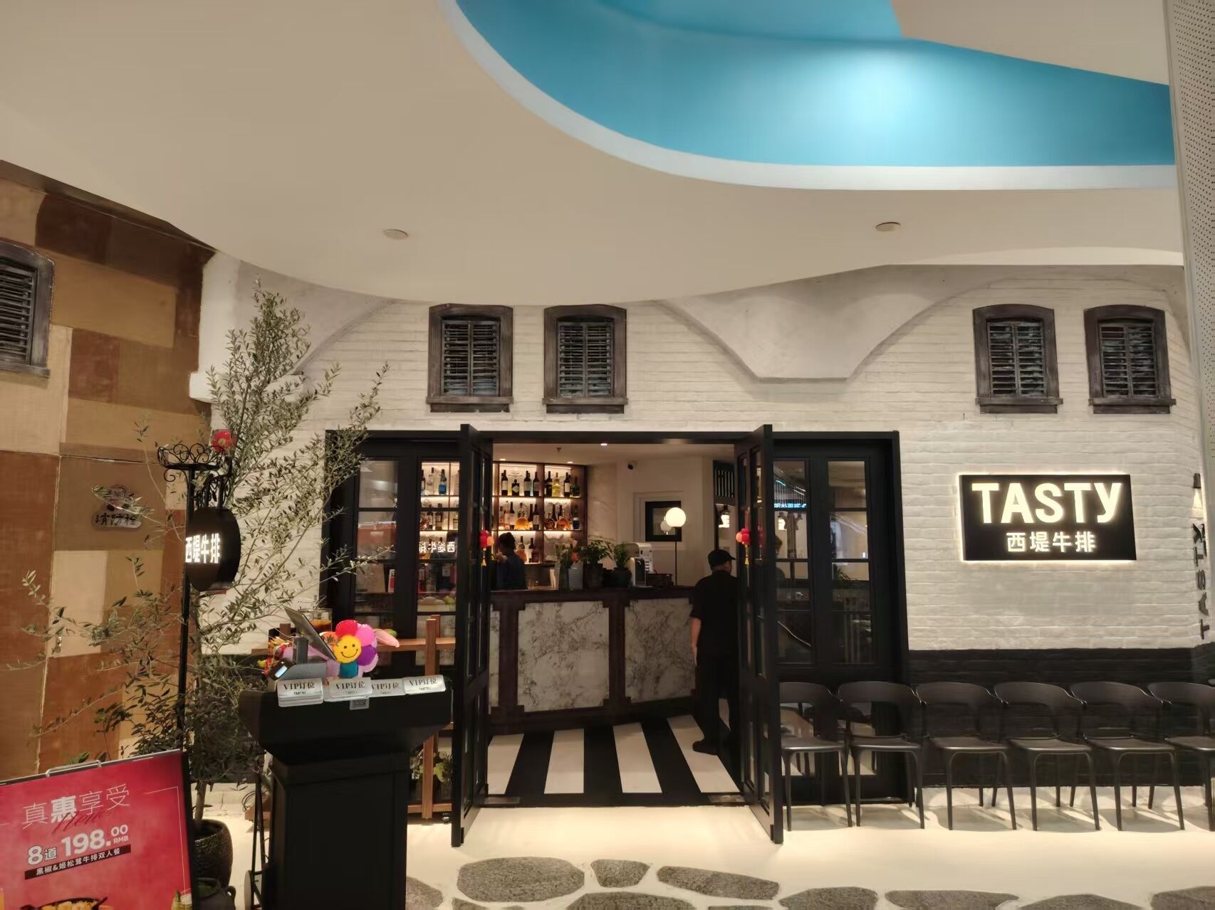A Tasty restaurant with a modern interior, a bar area, and a seating section.