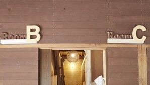 A wooden hallway with doors labeled "Room B" and "Room C". - Preta Torami - Hostel (Ichinomiya)