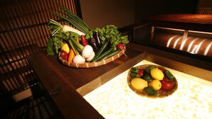 Una mesa de comedor con dos recipientes de frutas y verduras.