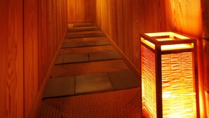 Un pasillo interior de madera con una escalera, una lámpara colgante y un cuadro en la pared.