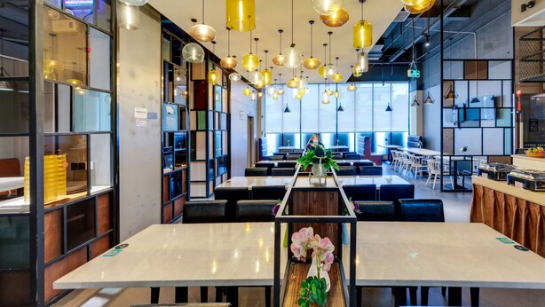 A modern restaurant with high ceilings, pendant lighting, and a central walkway. - Guangzhou Kardon Hotel Gorgeous (Guangzhou)