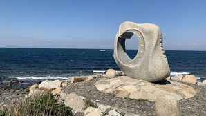 Una escultura de pedra al costat del mar.