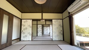 Una habitació japonesa tradicional amb tatami, panells shoji i un ventilador de sostre.