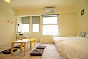 A bedroom with a bed, a desk, and two windows. - Chestnut Guest House (Taitung)