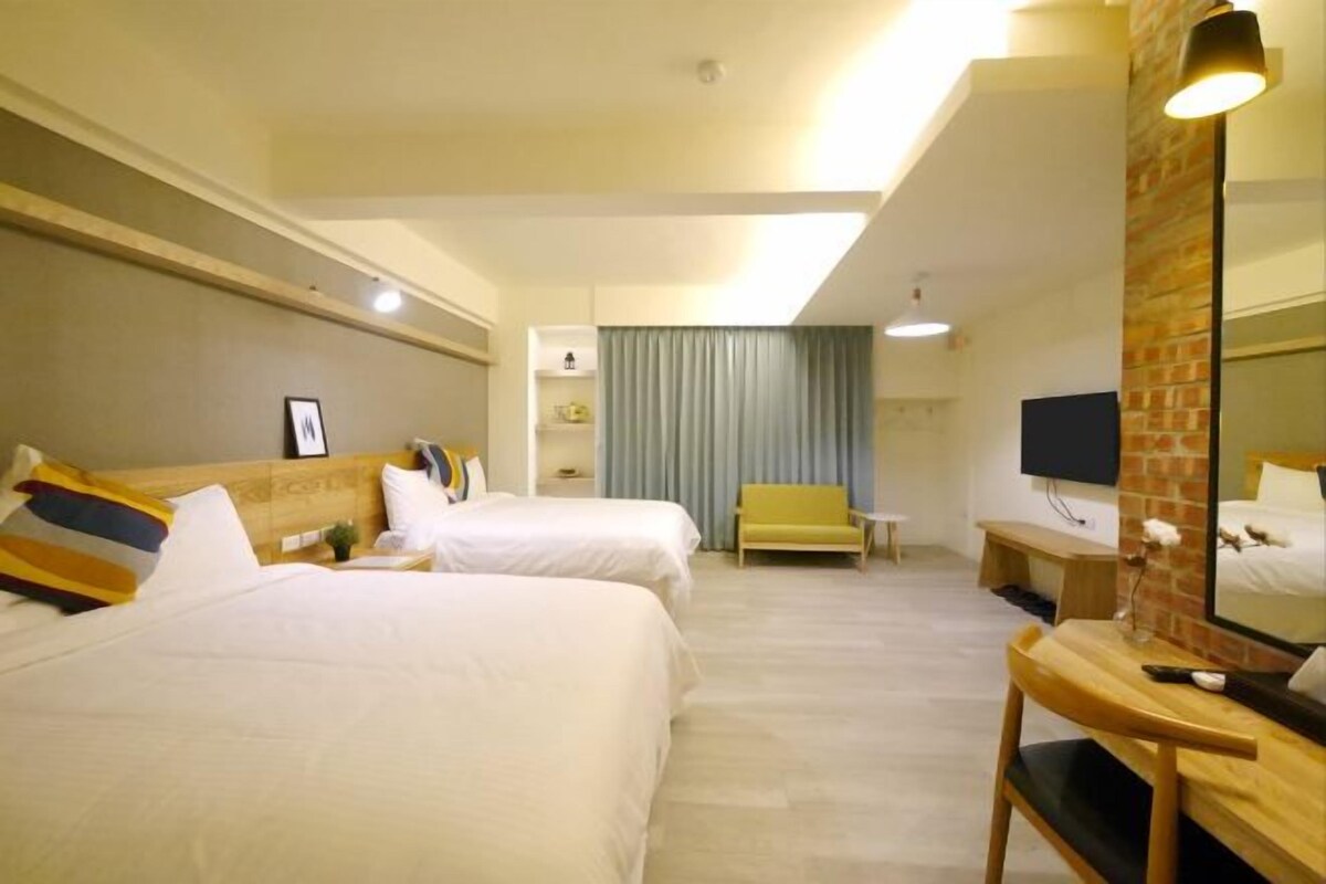 Une chambre d’hôtel avec deux lits, un bureau, une chaise, une télévision et un miroir.