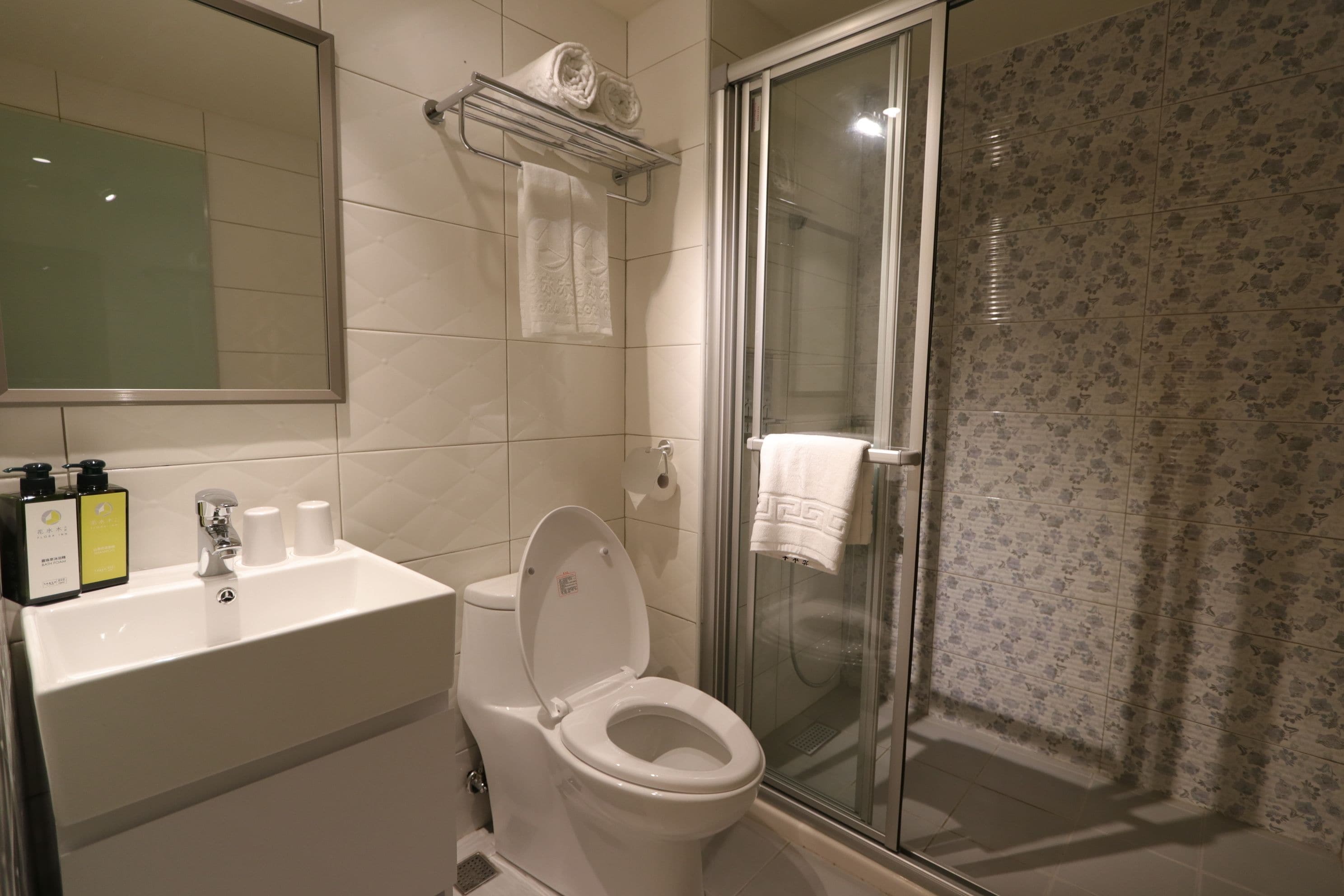 Une salle de bain avec des toilettes, un lavabo et une douche.