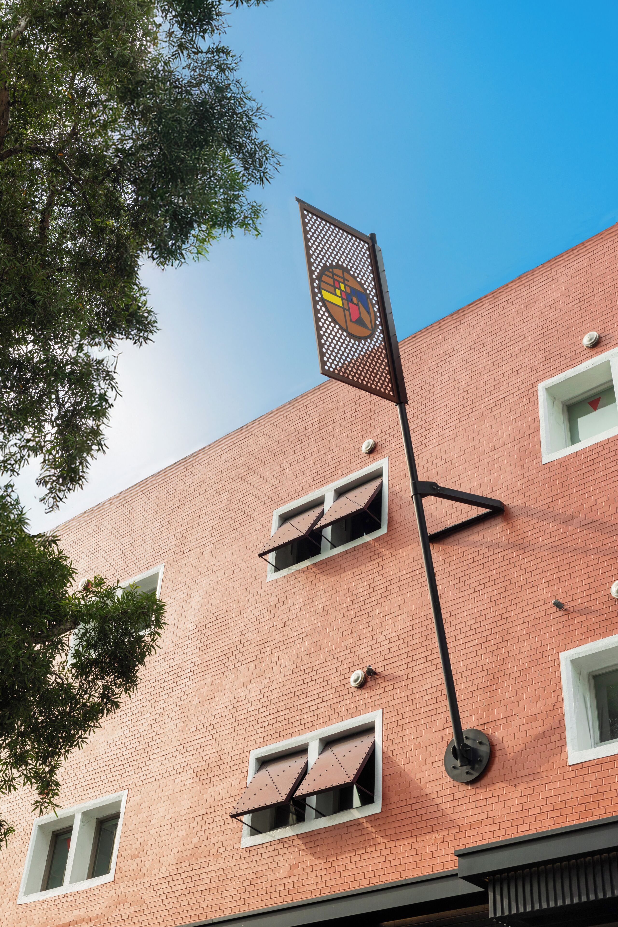Un edificio de ladrillo rojo con múltiples ventanas y un letrero en la fachada.