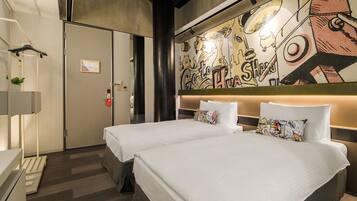 A hotel room with two beds, a large mural on the wall, and a modern design.
