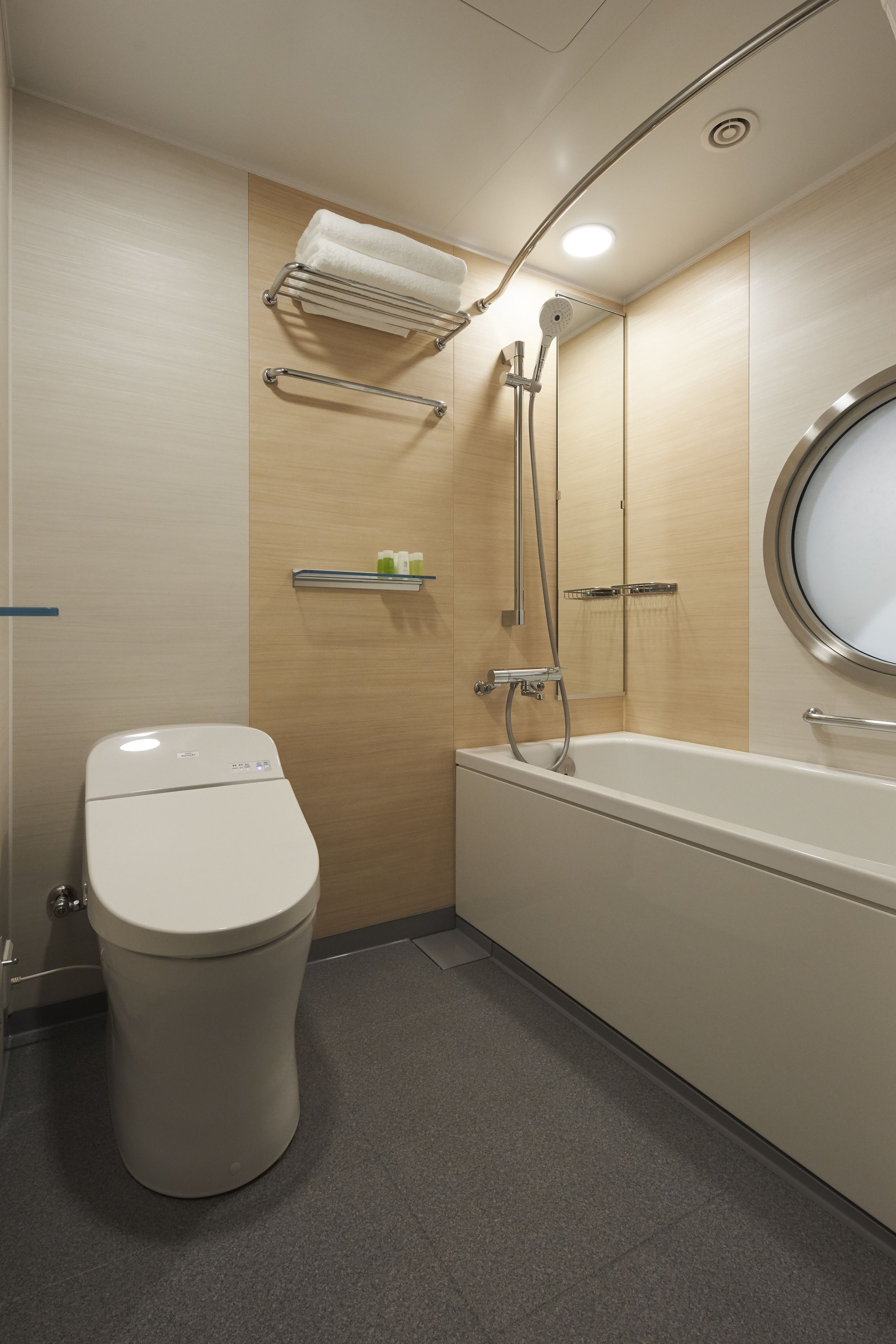 A modern bathroom with a toilet, a bathtub, and a shower.