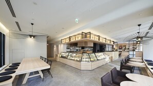 A modern restaurant with a central display case, multiple seating areas, and contemporary lighting fixtures. - Hotel 1899 Tokyo (Tokyo)