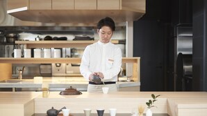 A modern kitchen with wooden cabinets, a stainless steel refrigerator, and a counter with tea sets and cups. - Hotel 1899 Tokyo (Tokyo)